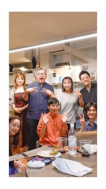 テーブルを囲んで集まった人たちの記念写真